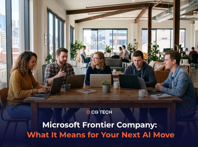 Team of business professionals collaborating on laptops in a modern office, discussing Microsoft's new Frontier Company AI announcement.